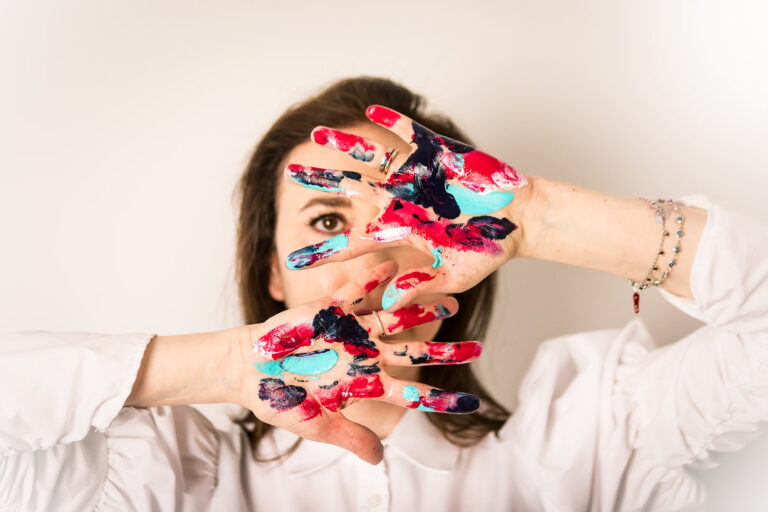 artista con mani colorate di vernice