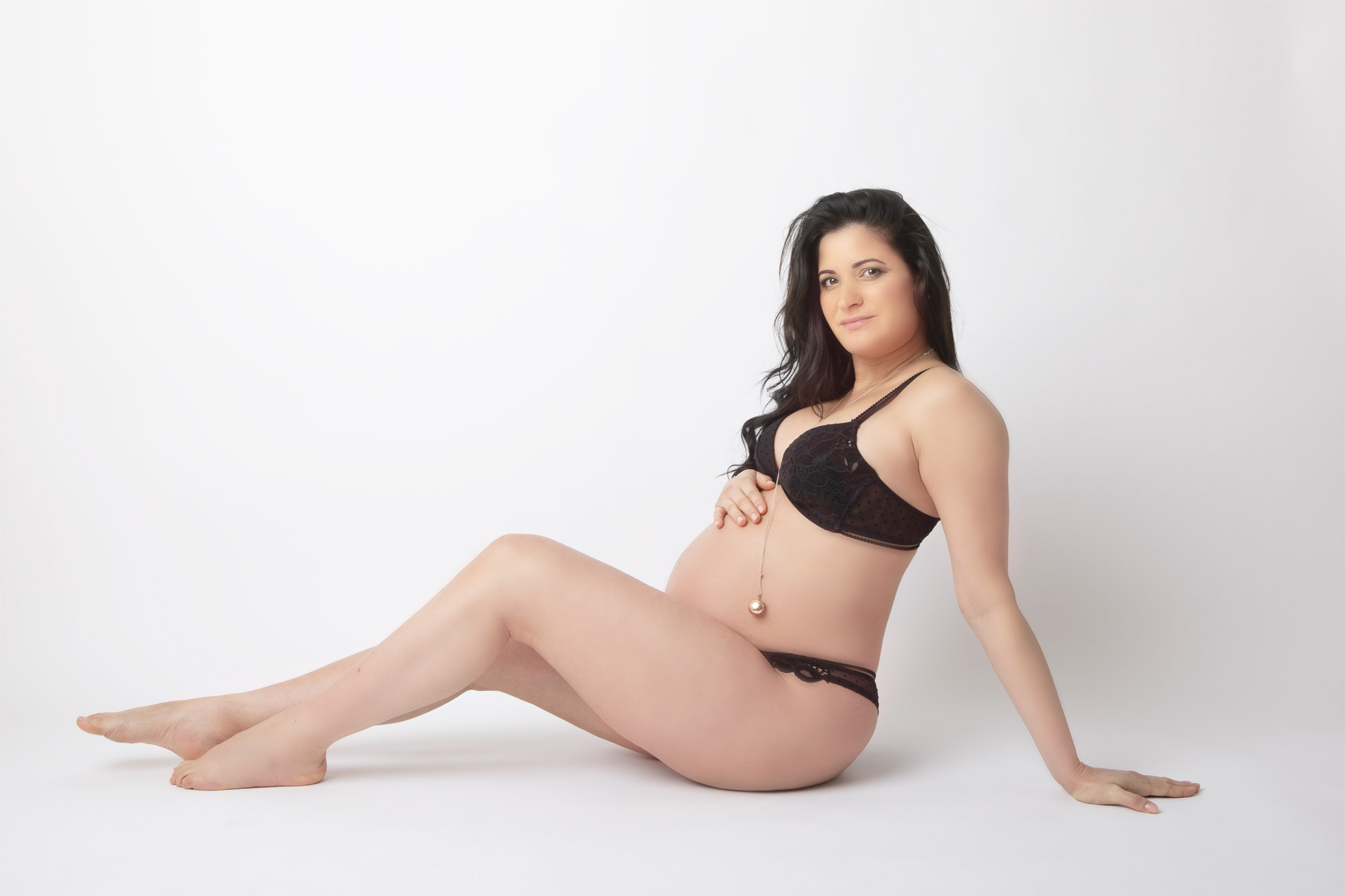 servizio fotografico donna gravidanza fondale bianco e donna lingerie