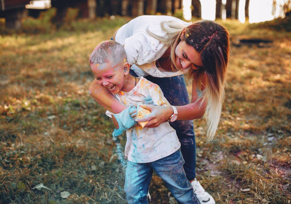 Family in a summer park. Mother in a white t-shirt. Cute little boy with paints on his face